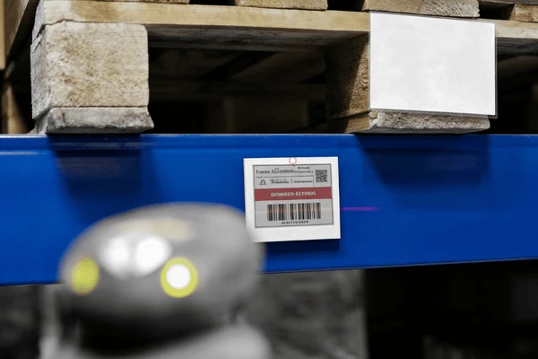 ESL labels on warehouse bin locations for inventory and pick-to-light operations Large-format electronic shelf labels used in warehouse bin locations showing lot numbers and reorder triggers